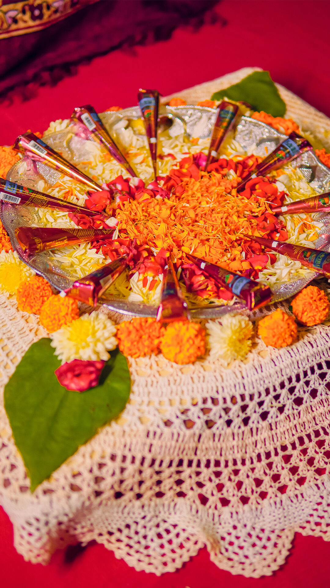 bunch of mehendi cones in a silver pot with flowers near it for mehendi ceremony 